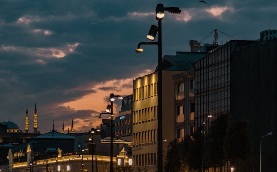 People walking under city streetlights